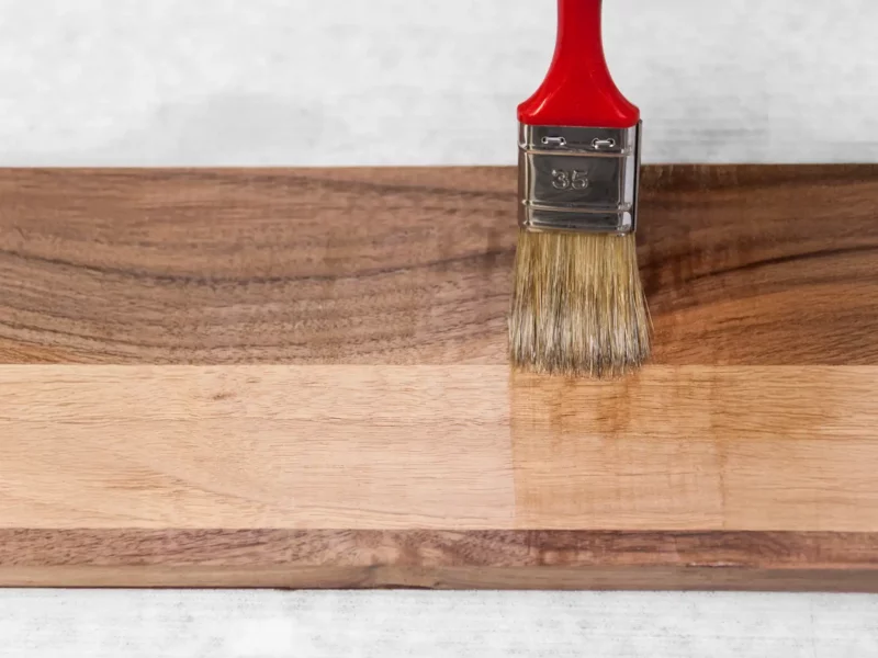 Pinselauftrag von Öl auf eine Holzprobe