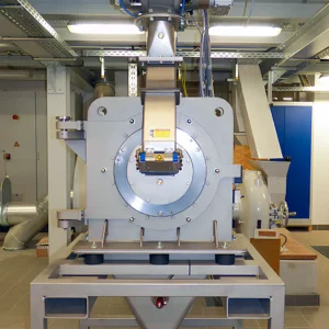 Große Wirbelstrommühle in einer Laborumgebung: Edelstahl‑Gehäuse mit Zuführtrichter und Absaugstutzen zur Feinvermahlung und Klassierung von Holzspänen.