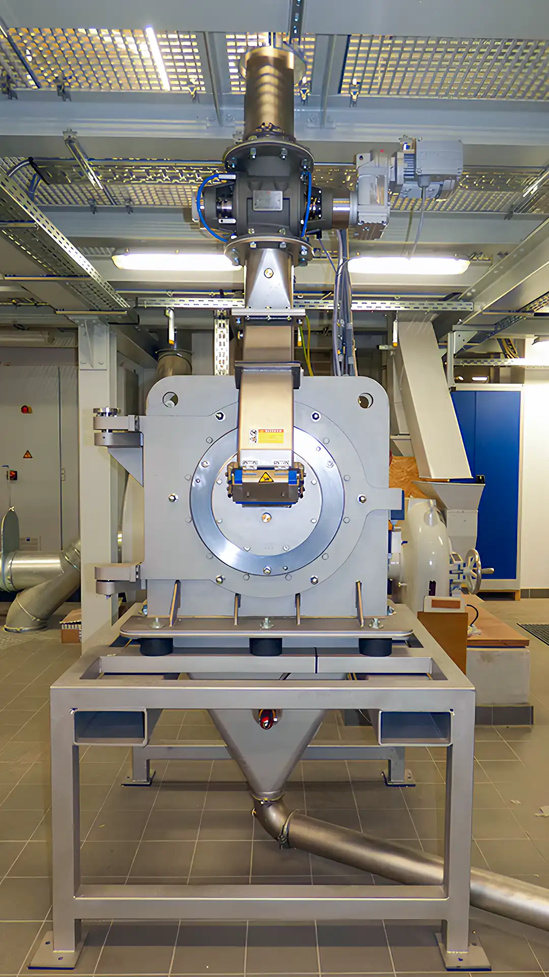 Große Wirbelstrommühle in einer Laborumgebung: Edelstahl‑Gehäuse mit Zuführtrichter und Absaugstutzen zur Feinvermahlung und Klassierung von Holzspänen.