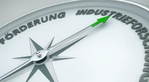 Nahaufnahme eines Kompasses mit grünem Pfeil – symbolisch für Forschungskoordination und strategische Ausrichtung.
