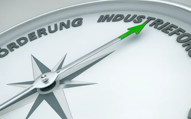 Nahaufnahme eines Kompasses mit grünem Pfeil – symbolisch für Forschungskoordination und strategische Ausrichtung.