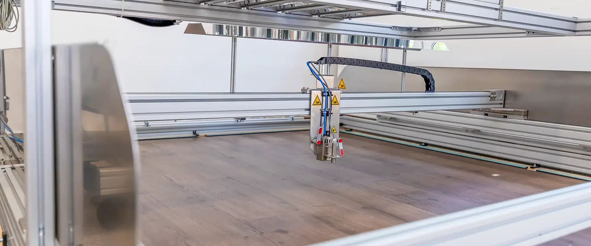 Der Hot-Spot-Prüfstand des IHD. Der Z-Weg-Sensor fährt über einen Laminatfußboden, um deren Verformung in X-, Y- und Z-Richtung unter Hitzeeinwirkung zu messen.