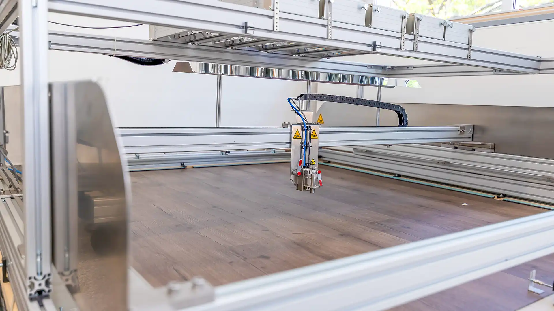 Der Hot-Spot-Prüfstand des IHD. Der Z-Weg-Sensor fährt über einen Laminatfußboden, um deren Verformung in X-, Y- und Z-Richtung unter Hitzeeinwirkung zu messen.