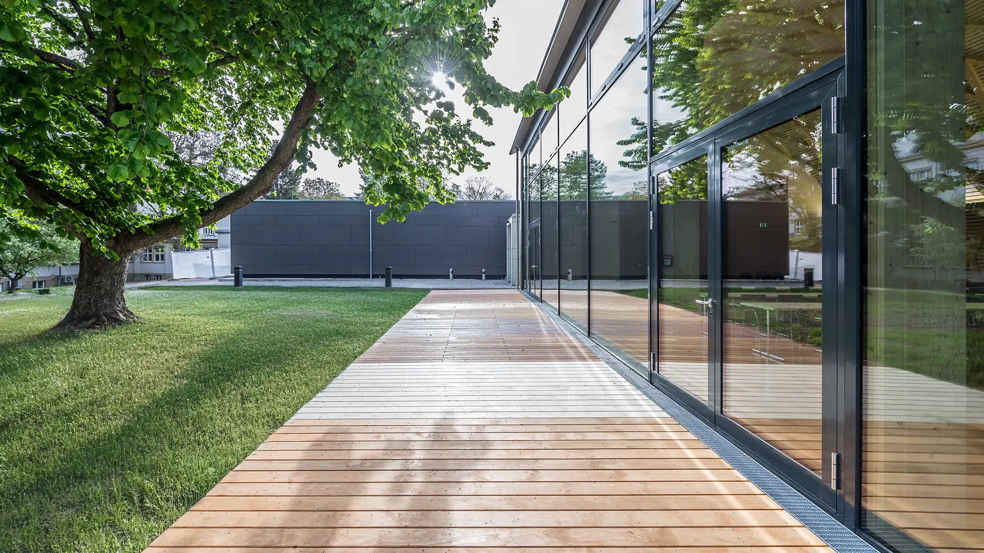 Holzterrasse des Konferenzzentrums mit großer Glasfront