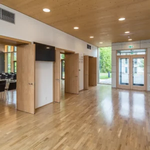 Helles Foyer mit Holzboden und Holzdecke. Blick in Richtung des Konferenzsaales