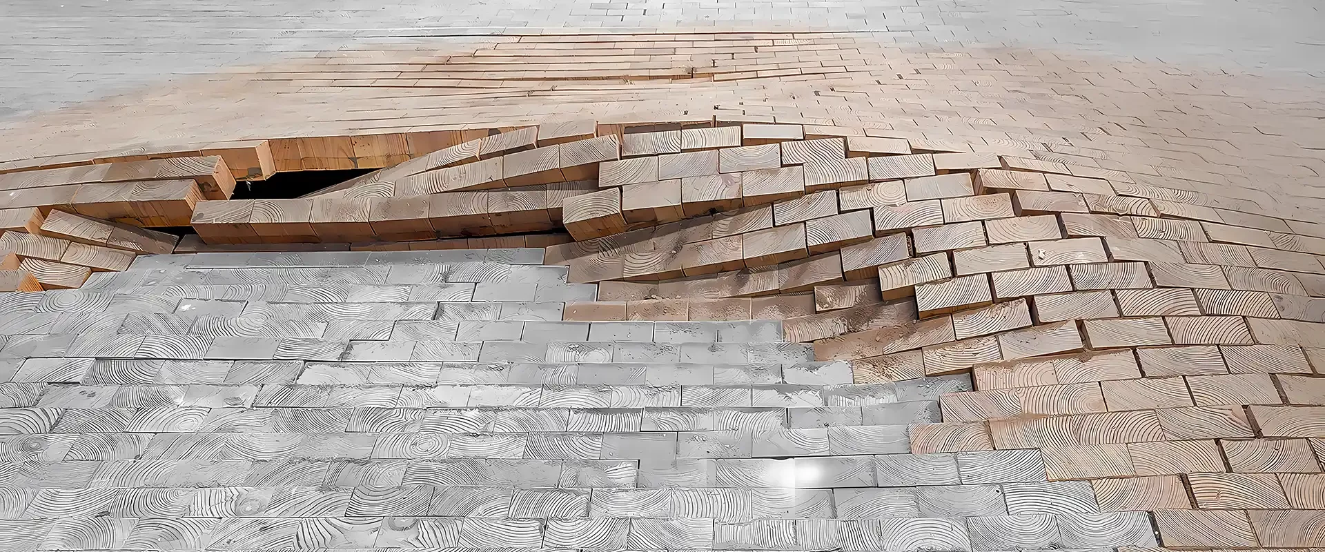 Schadensanalyse an einem Holzfußboden: Stirnholz-/Klötzchenparkett ist großflächig aufgewölbt; einzelne Holzklötze stehen hoch und bilden eine kraterartige Vertiefung.