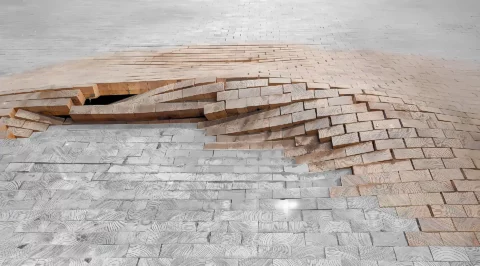 Failure analysis on a wooden floor: End grain/block parquet is bulging over a large area; individual wooden blocks are standing up and forming a crater-like depression.