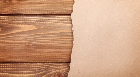 Wooden surface with torn paper edge symbolizing documentation and research