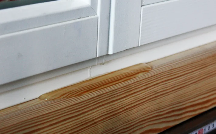 Harzaustritt an Holzfensterbank unter Kunststofffensterrahmen