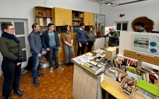 Besuchergruppe bei einer Laborführung im Holztechnologie-Labor mit Holzmustern und Prüfobjekten