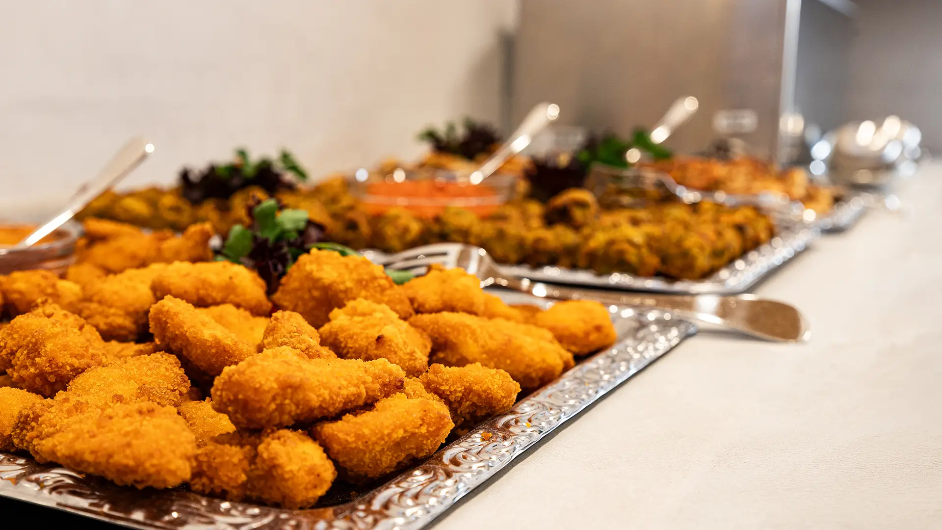 Buffet mit panierten Fingerfood-Snacks auf Servierplatten bei einer Veranstaltung