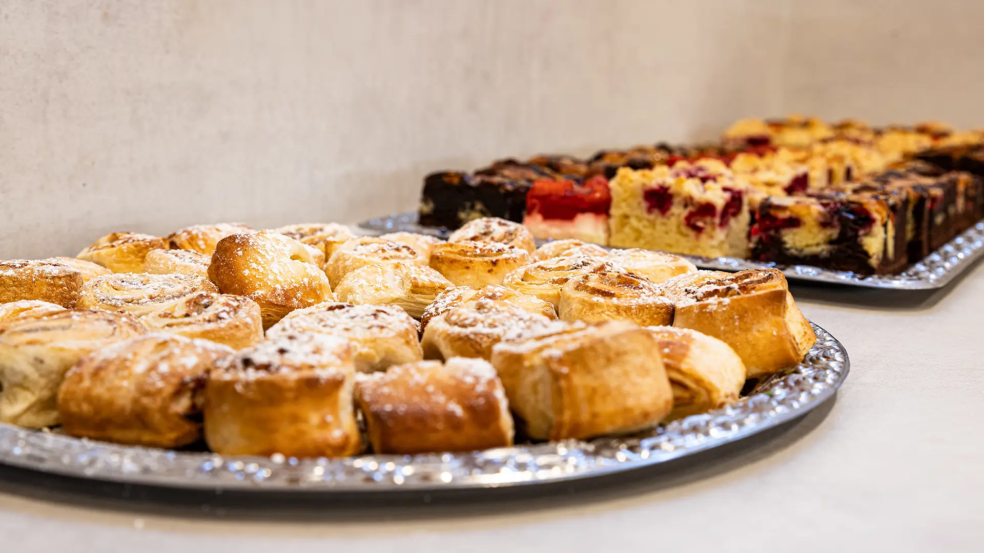 Dessertbuffet mit Gebäck, Zimtschnecken und Obstkuchen auf Servierplatten
