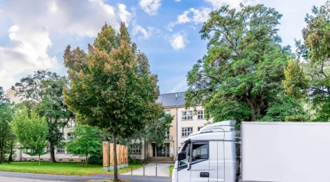 Institute building with trees and truck in front of the entrance