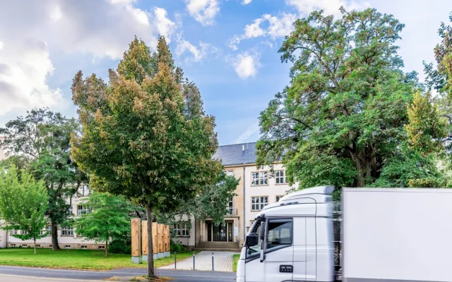 Institute building with trees and truck in front of the entrance